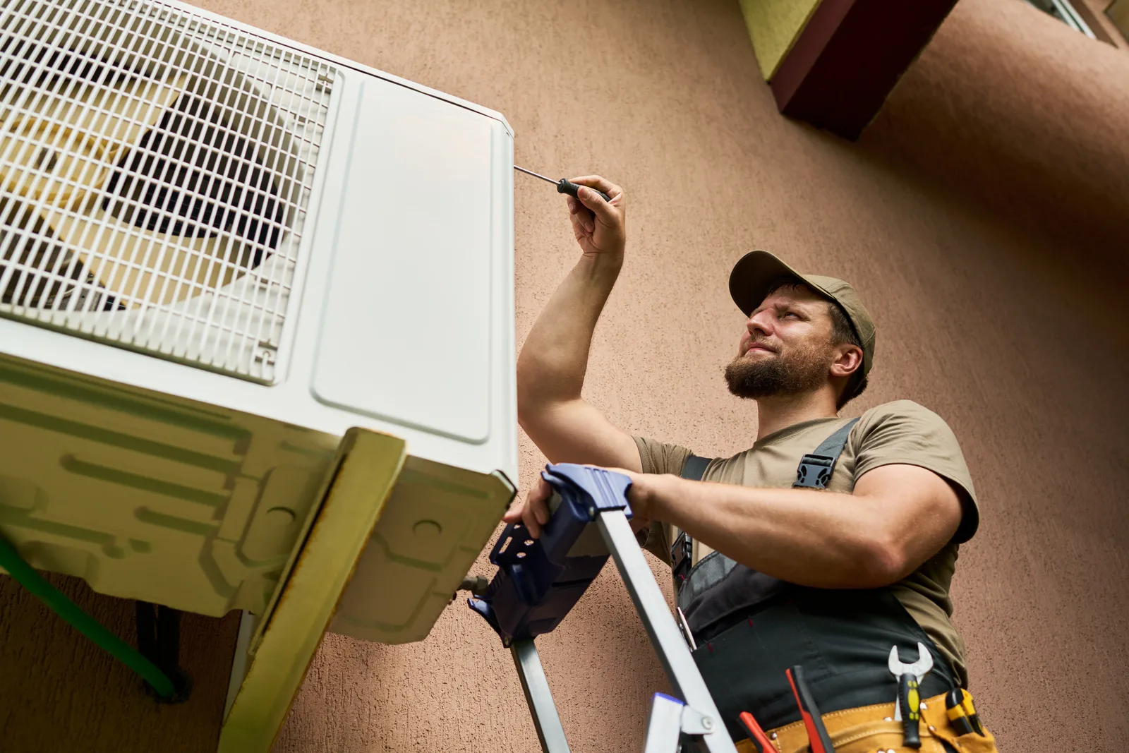 HVAC technician servicing an outdoor air conditioning condenser unit